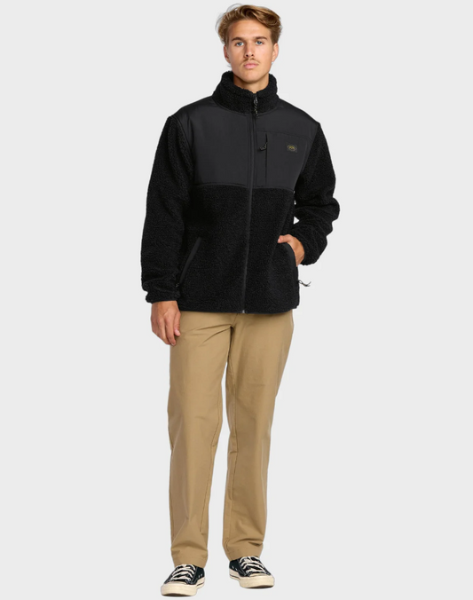 Billabong Boundary Summit Mock Neck Zip Crew Jacket in black from front on model in khaki trousers