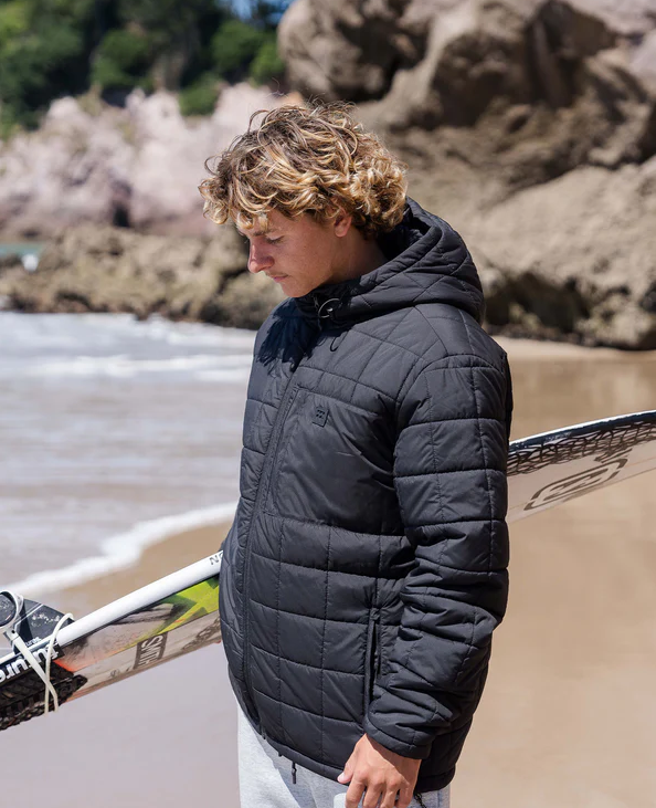 Billabong Journey Puffer Jacket in black on model on beach