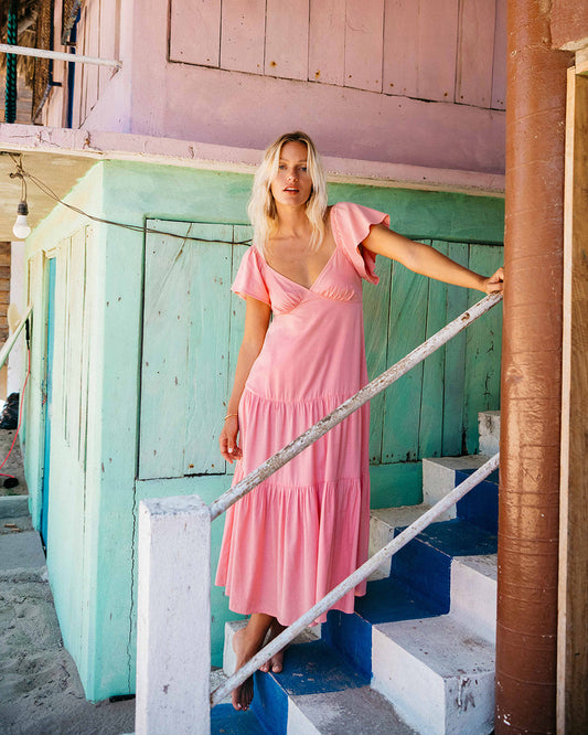 Billabong Last Light Dress in light sorbet colour on model standing on stairs