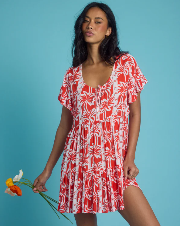 Billabong Row Of Palms Tiered Dress in red aloha colourway on model from front with blue background