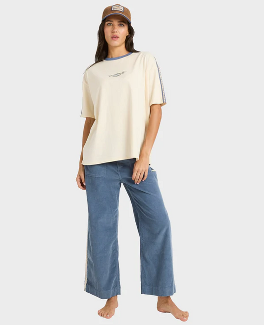 Billabong Sea Tone Women's Corduroy Pants in stone blue on model in off white Billabong tee from the front
