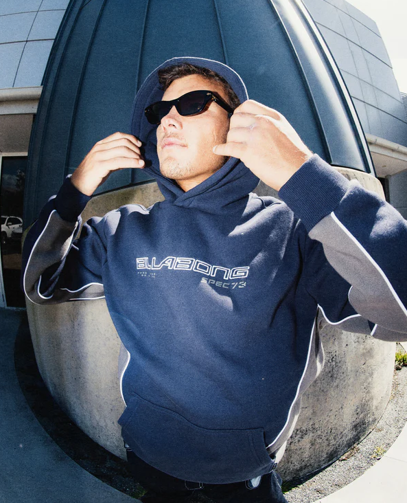 Billabong Spec 73 Pop Hoodie in vintage indigo on a model by a building in fish eye view