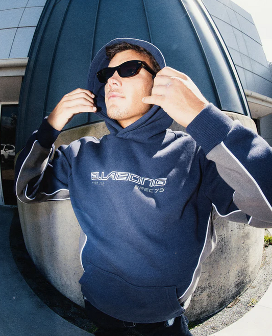 Billabong Spec 73 Pop Hoodie in vintage indigo on a model by a building in fish eye view