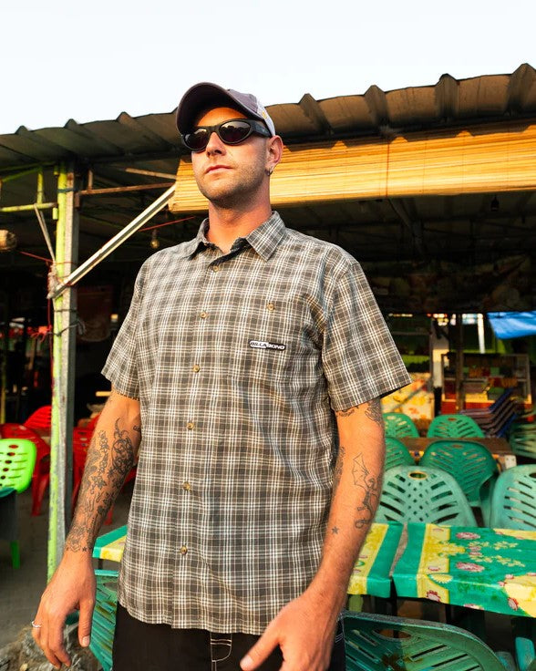 Billabong Spec Mogul Short Sleeve Shirt in dark forest colourway on model at a market