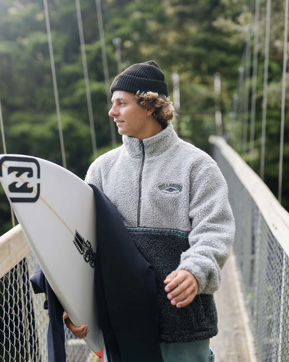 Billabong Tombstone Half Zip Pullover Fleece in oatmeal heather colourway on surfer holding his surfboard