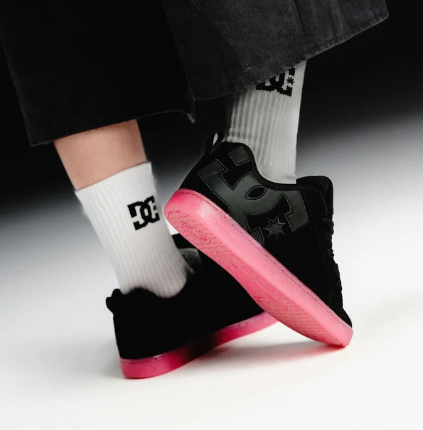 DC Shoes Women's Court Graffik Shoes in black with pink soles showing a pair on someone's feet