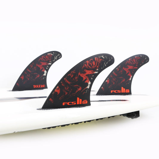 FCS II FT FILIPE TOLEDO PC LARGE TRI FIN SET in black and red mounted in surfboard