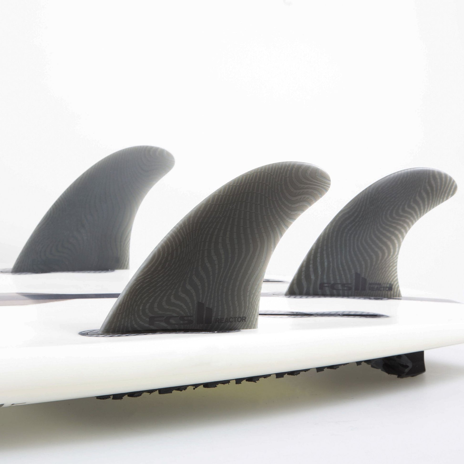 FCS II Reactor Neo Glass Medium Tri Fin Set showing all three fins in a board