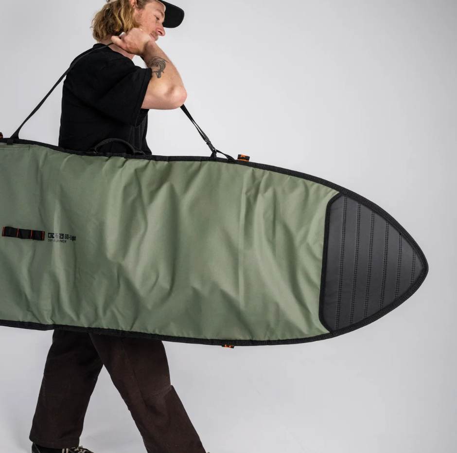 FCS 9'2 Day Runner Longboard Bag in alpine colourway being carried by a surfer