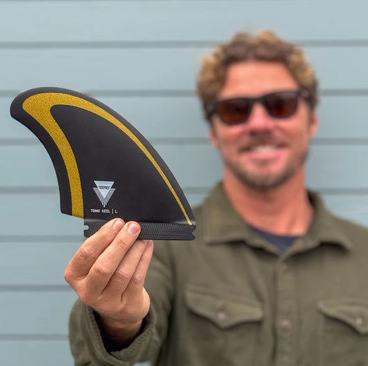 Daniel Tomo Thomson holding a Firewire Tomo Revo Max Twin Keel Surfboard Fin