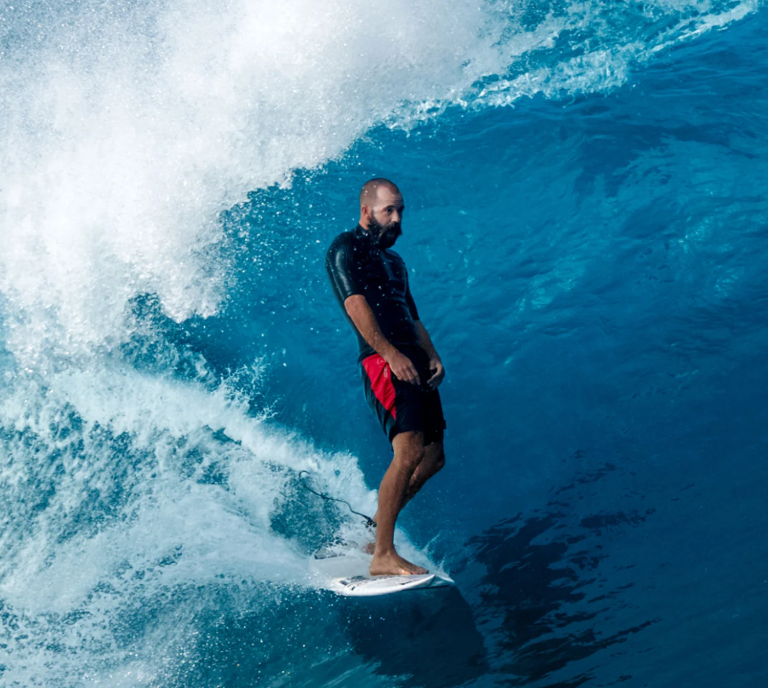 Florence Marine X Cordura Airtex 18.5" Boardshorts in black with red detailing on bearded surfer in the barrel