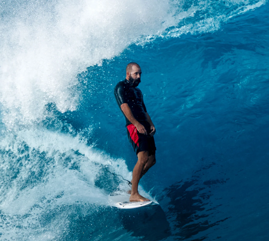 Florence Marine X Cordura Airtex 18.5" Boardshorts in black with red detailing on bearded surfer in the barrel