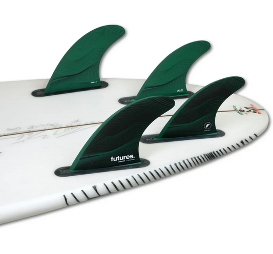 Futures Honeycomb F8 Quad Large Fin Set in black and green in the back of a surfboard
