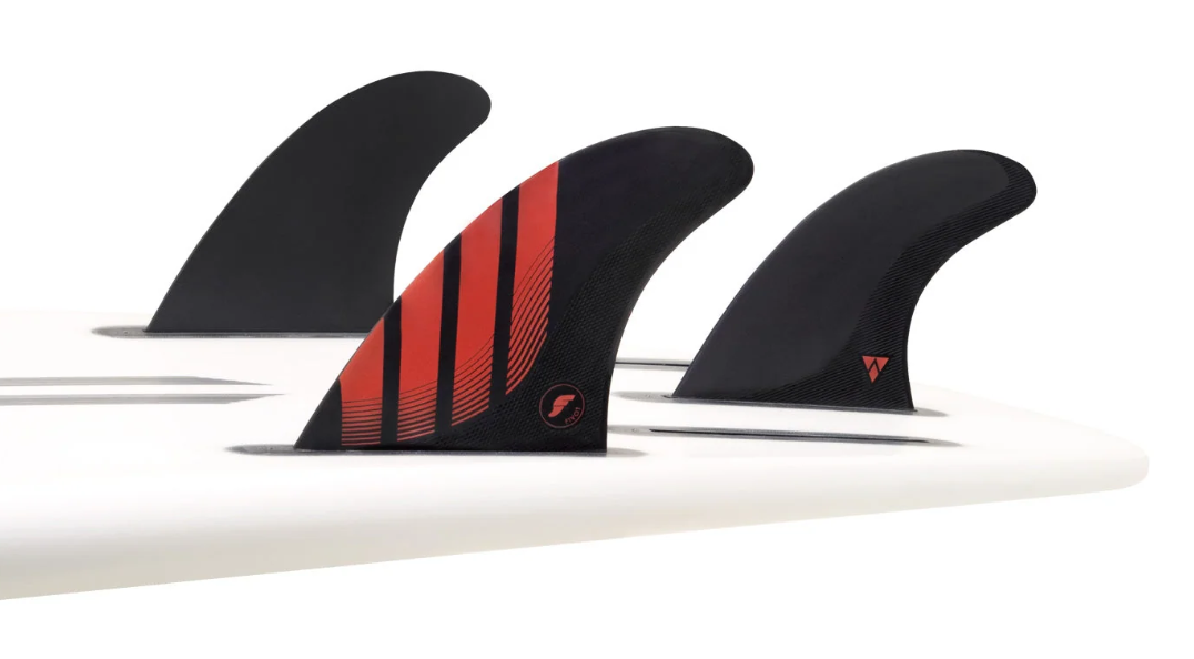 Futures Fins Pivot Alpha Carbon Thruster Fins large black and red in the tail of a surfboard