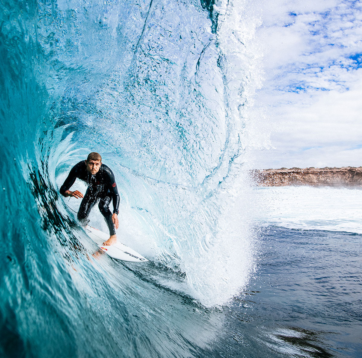 Mick Fanning wearing his top end Rip Curl Fusion wetsuit surfing inside a right hand barrel