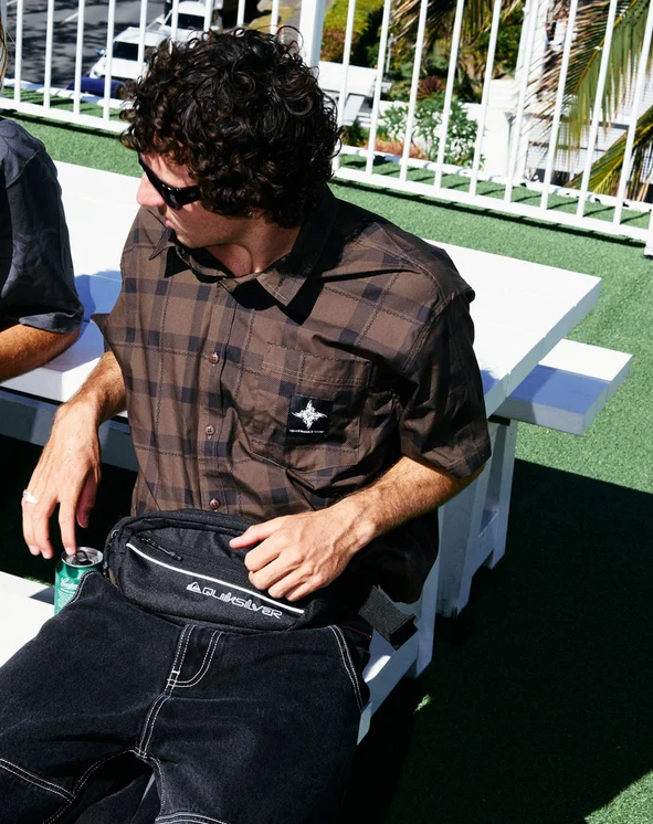 Quiksilver Edition Woven Short Sleeve Shirt in turkish coffee colourway on model sitting on white becnh