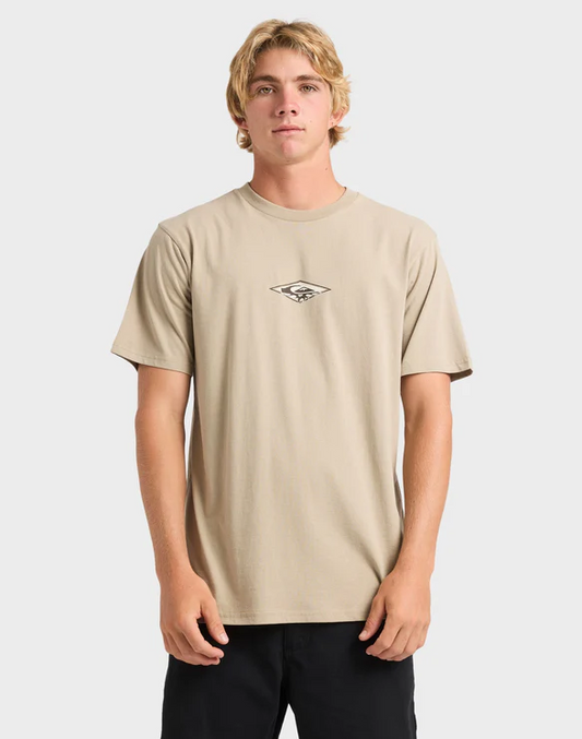 Man wearing a beige t-shirt with a small logo on a plain background