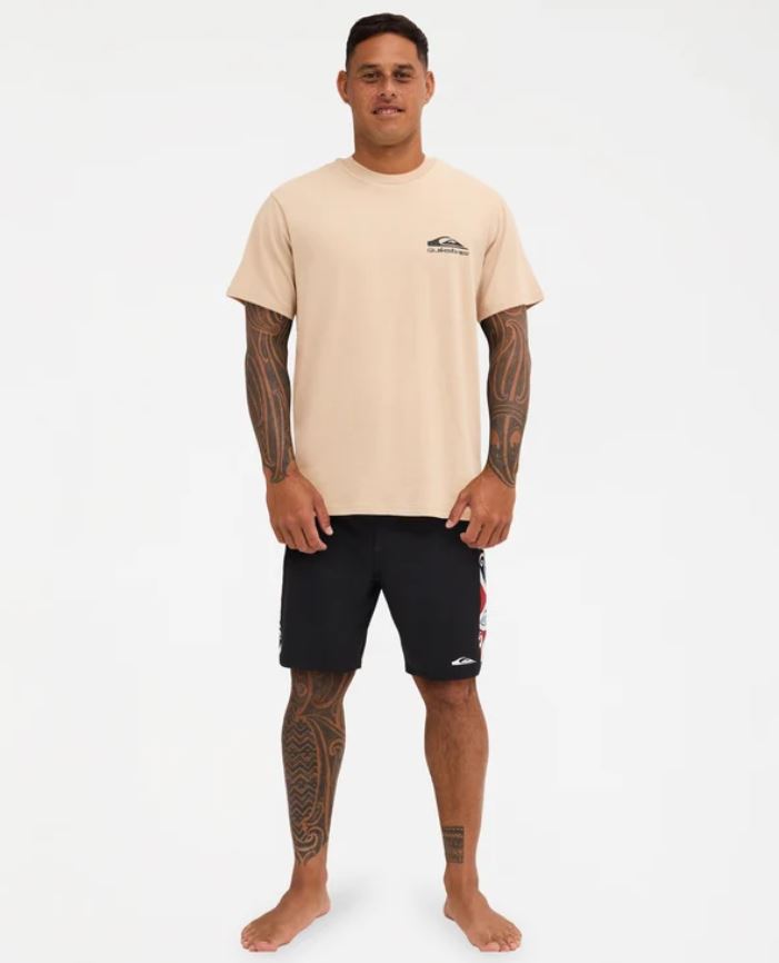 Quiksilver Tai Kehu Manu T-Shirt in light khaki on Kehu Butler in black Maori boardshorts from the front