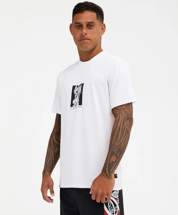 Quiksilver Tai Kehu Marakihau Men's Maori T-Shirt in white on Kehu Butler in Quiksilver Maori boardshorts from the side