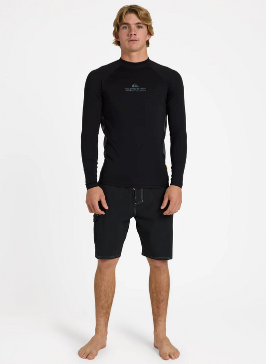 Quiksilver UV+ Long Sleeve Heater Thermal Rash Top in black on model in black boardshorts from the front