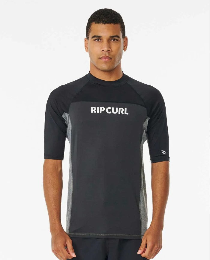 Dark haired model wearing Rip Curl Drive UPF Men's S/S Rash Tee in black and charcoal