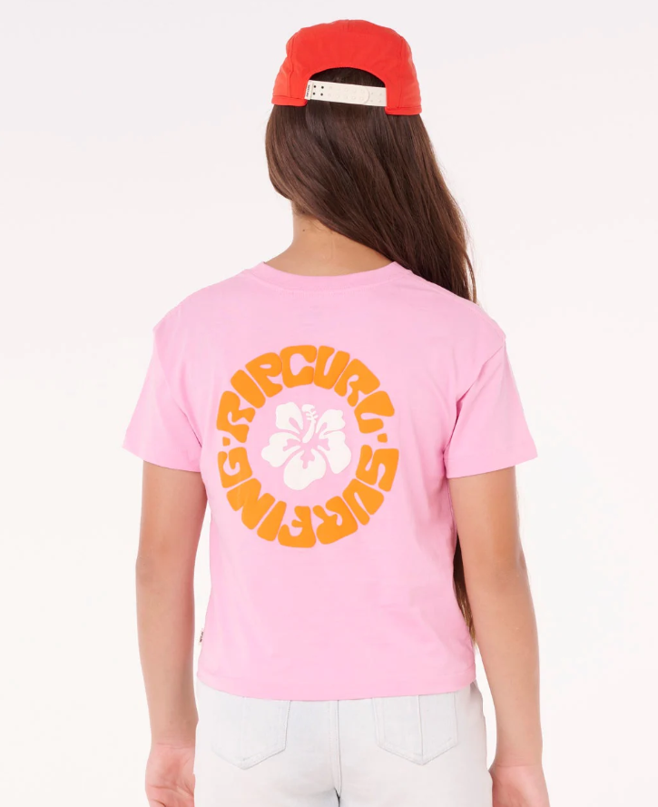Rip Curl Girl's Surf Puff Baby Crop Tee in pink on girl model in denim shorts and red cap from rear