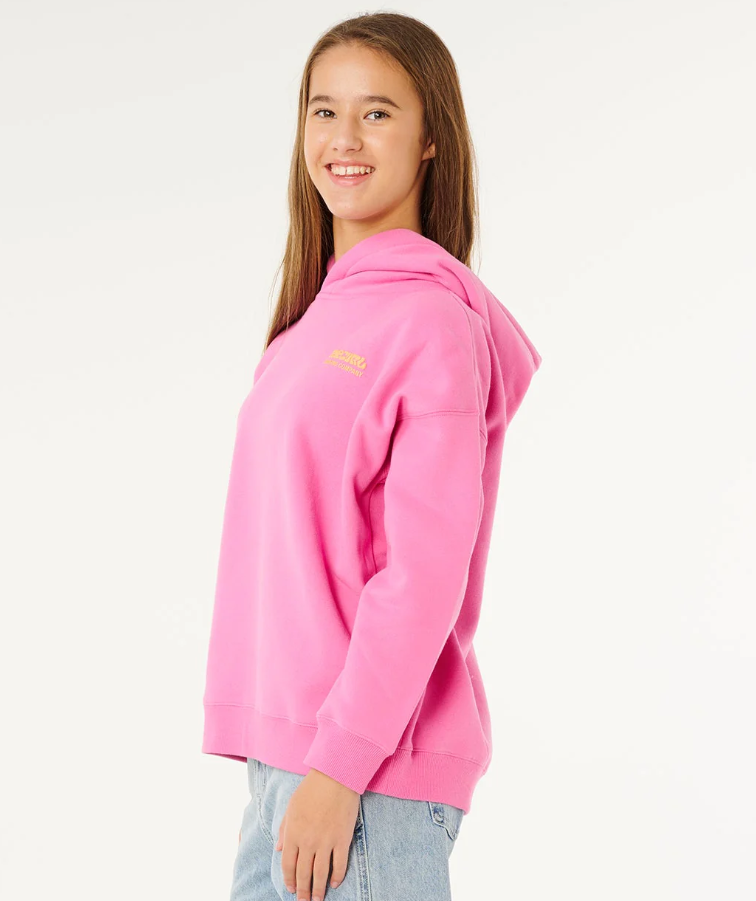 Rip Curl Girl's Surf Puff Heritage Hoodie in pink on model in light blue jeans from side