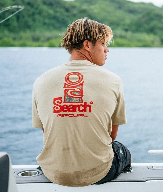 Rip Curl Vaporcool Search Stack Mens T-Shirt in khaki with red print on model by a lake from the rear