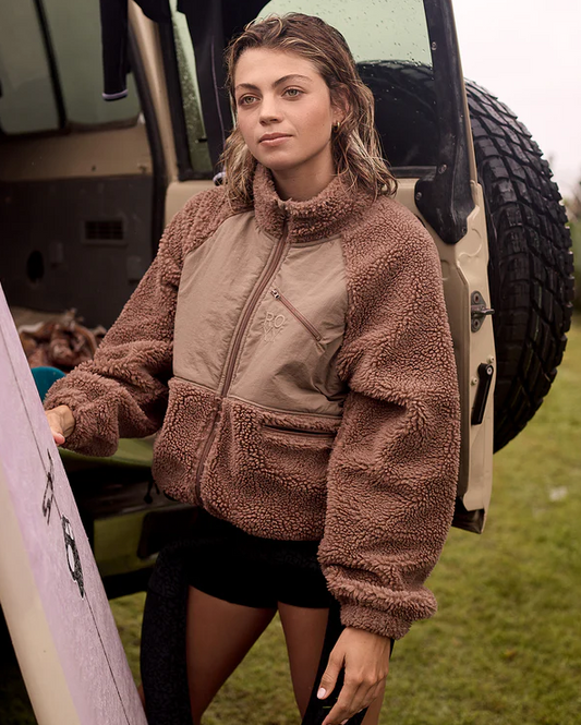 Roxy At Dusk Women's Jacket in mocha on model holding her surfboard