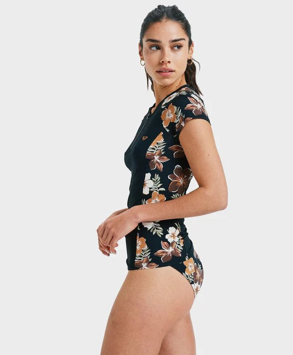 Roxy Cap Sleeve Half Zip Lycra  in black with almond tropical feels detailing on side on model from side