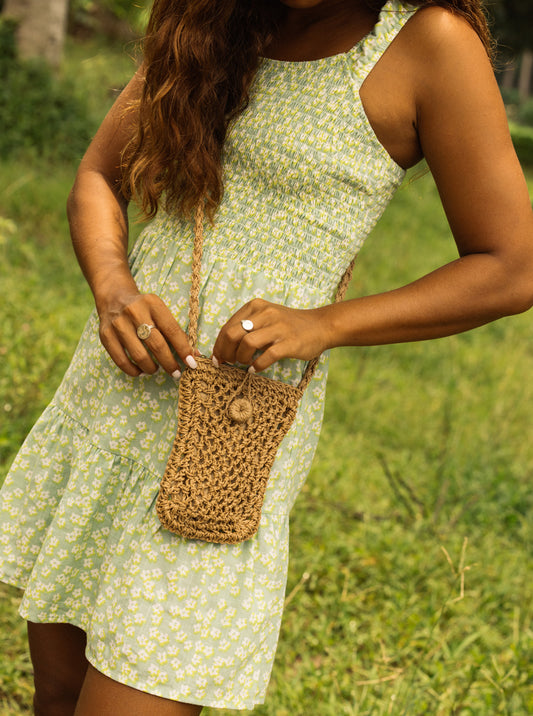 Roxy Coco Passion Crossbody Bag in natural held by model in green dress