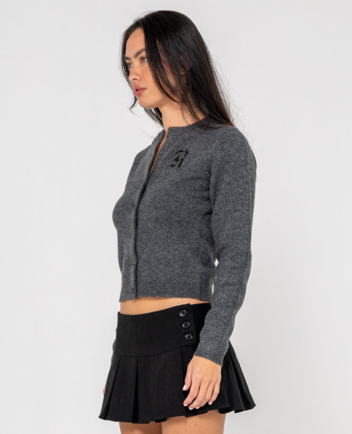 Rusty Academy Women's Cardigan in charcoal marle on model in black skirt from side