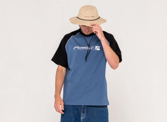 Rusty Bradman Wide Brim Hat in light khaki on model in blue tee
