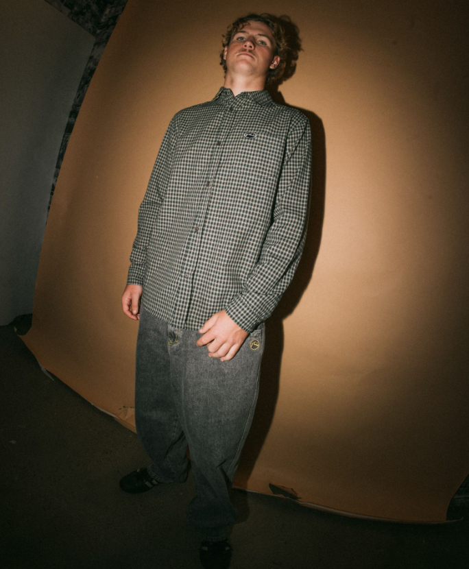 Rusty Datsun Check Long Sleeve Shirt in dark green on model from front with brown background