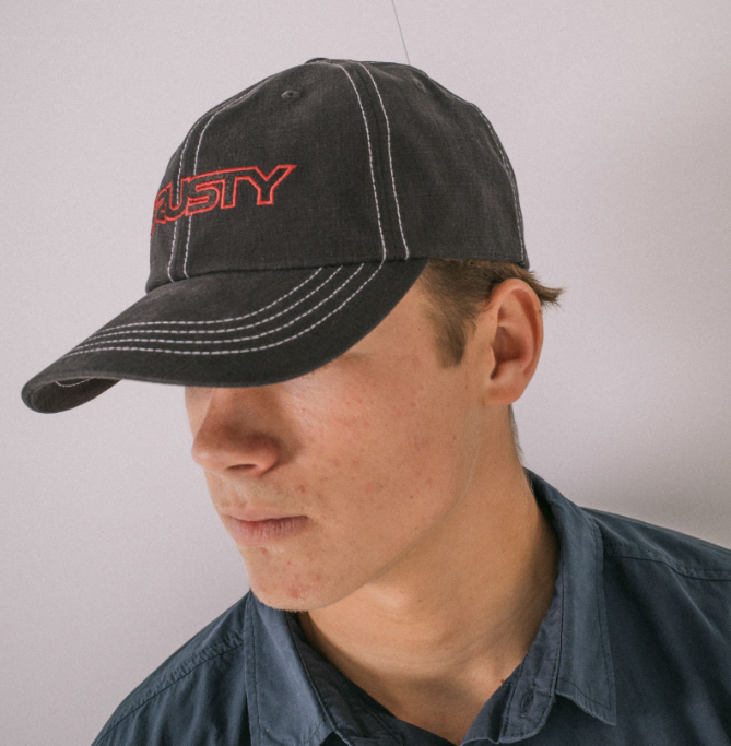 Rusty Dead End Dad Cap in washed black with red embroided print on mans head side front veiw