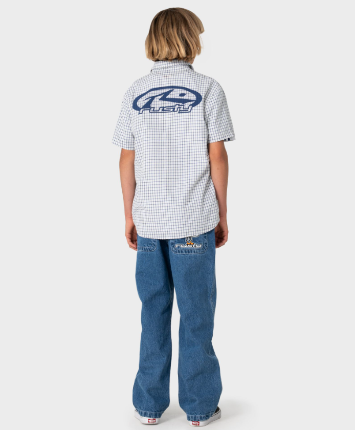 Rusty Defender Boys Short Sleeve Shirt in cream check on model in blue jeans from the rear