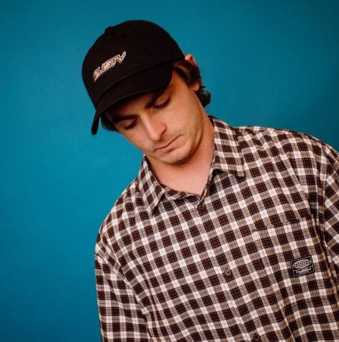 Rusty Flip Daddy Dad Cap in black on a model wearing a plaid shirt in front of a blue background