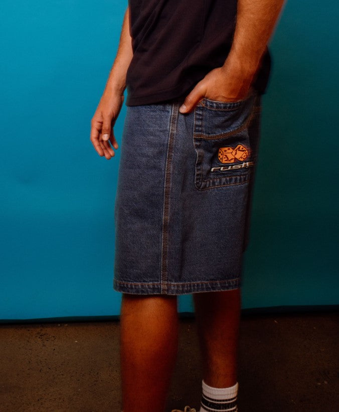Rusty Flip Daddy Low Ballin 23" Denim Shorts in middy blue on model in black and white t-shirt from rear