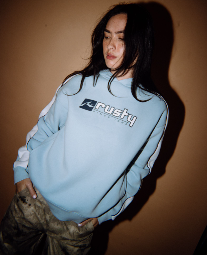 Rusty Hailstone Oversized Hooded Fleece in retro blue on model from front with brown background