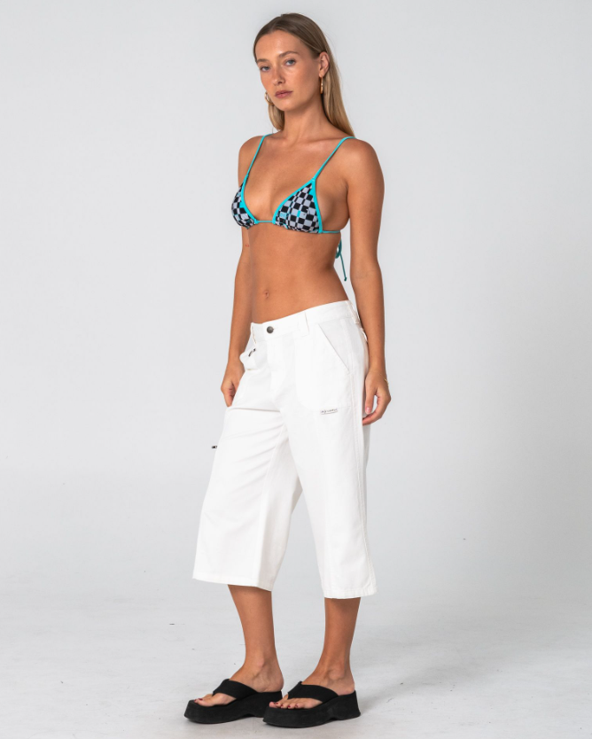Rusty It Gyrl Low Rise Capri Cargo Pant in white on model in checked bikini top from the front on side angle