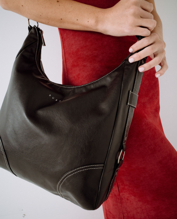 Rusty Mallory Crossbody Bag in black on model in red dress