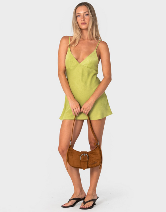 Rusty Rodeo Suede Handbag in nutshell colourway held by model in green mini dress