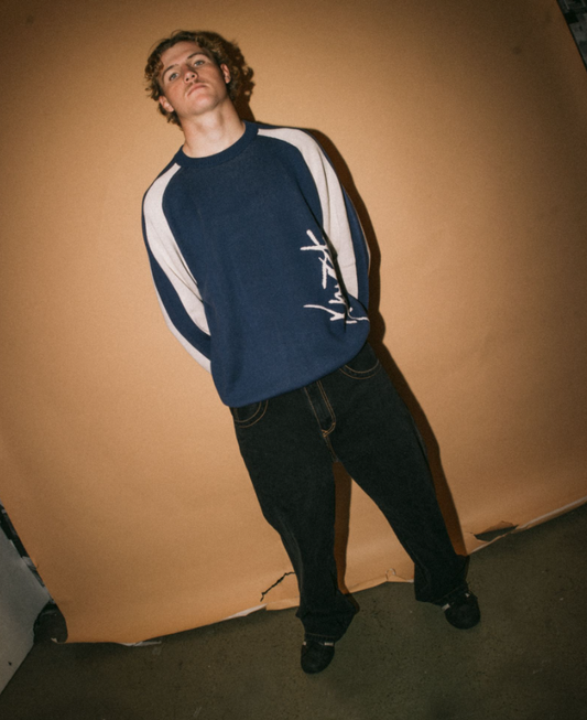 Rusty Roll Safe Boxy Knitted Men's Crew in blue with white detail on model with brown background