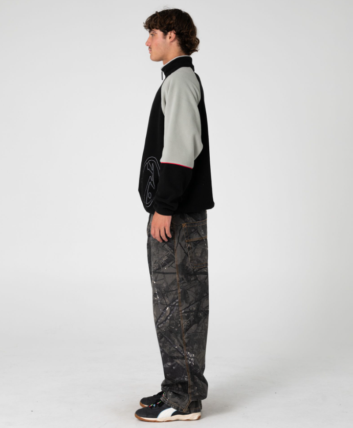 Rusty Tectonic Quarter Zip Polar Fleece in black on model from side 