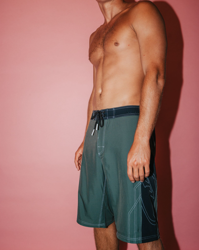 Rusty Tombstones Fixed Waist 21" Boardshorts in army green from side with red background