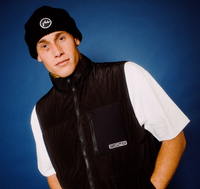 Rusty United Thinsulate Men's Beanie in black on model in black rusty puffer vest from front