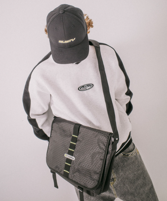 Rusty Voltage Messenger Bag in graphite and black on a model's shoulder