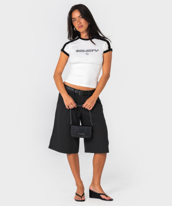 Rusty Wild Saint Belt Bag held by model with the chain strap