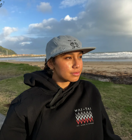 Wai-Tai Aotearoa Tipua 5 Panel Cord SB Unisex Maori Design Cap in slate blue on female at the beach