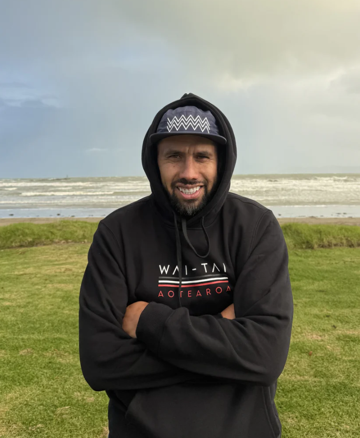 Wai-Tai Aotearoa Tohu 5 Panel Unisex Amphibian Cap in navy on male at Waikanae Beach in Gisborne